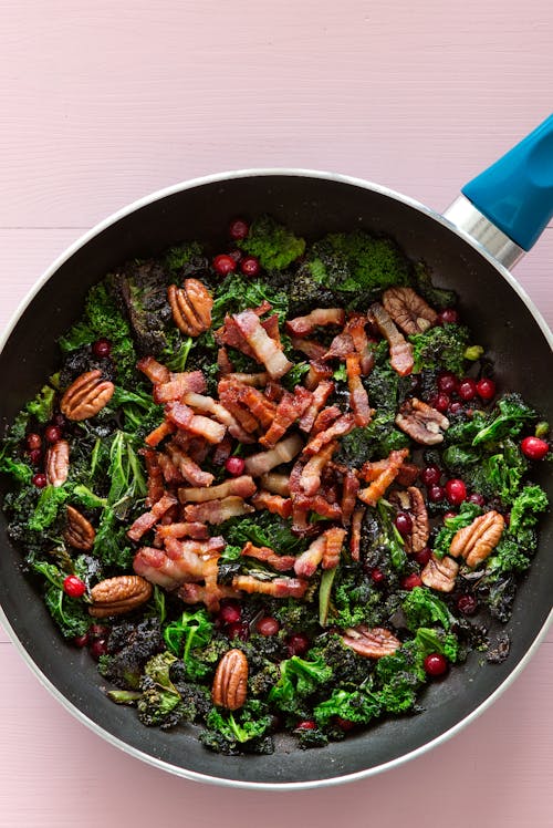 Col rizada keto frita en mantequilla con carne de cerdo y arándanos