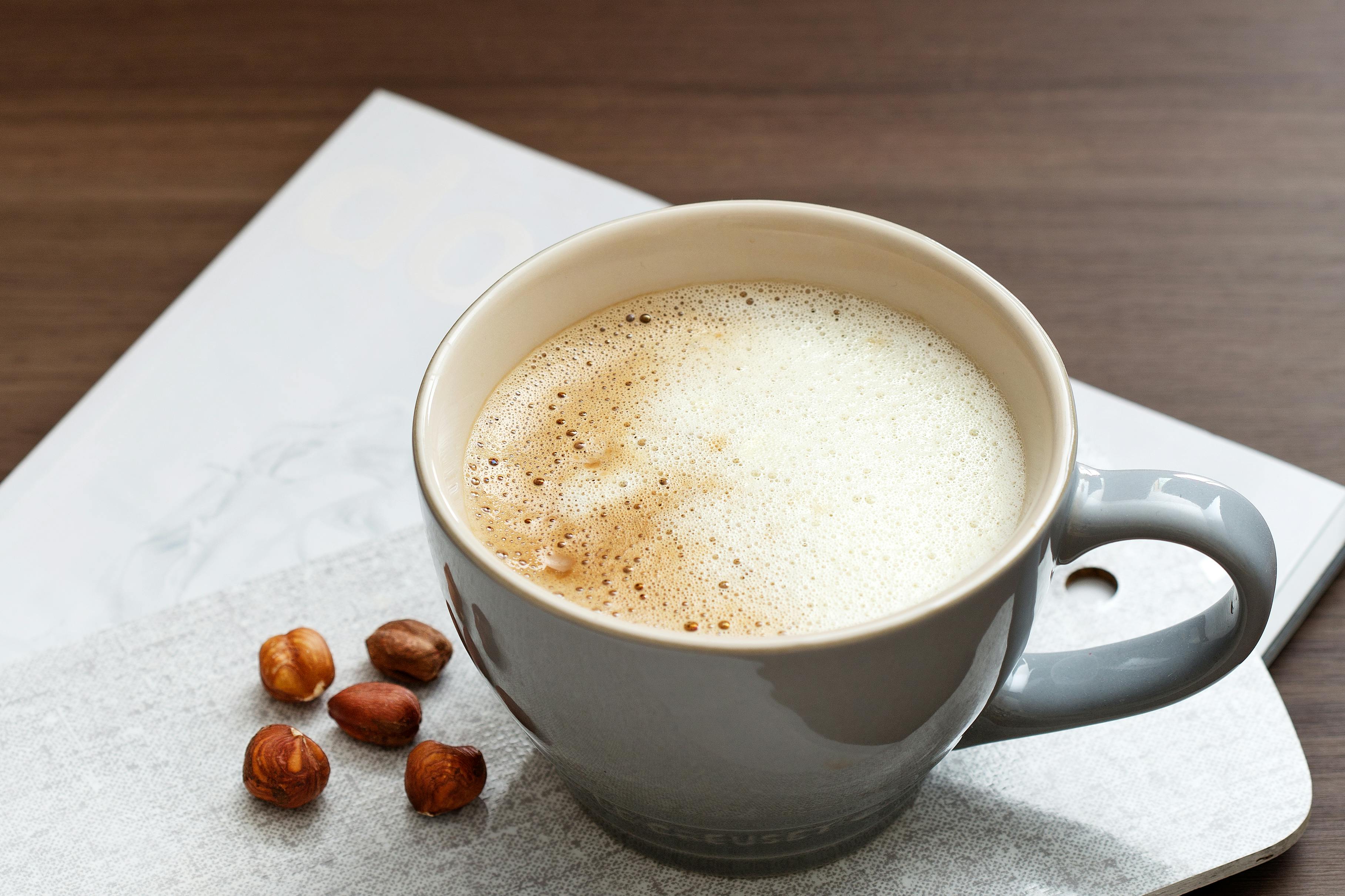 В кофе можно добавить сливки. Кофе со сливками. Чашка кофе со сливками. Ореховый кофе. Кофе с орешками.
