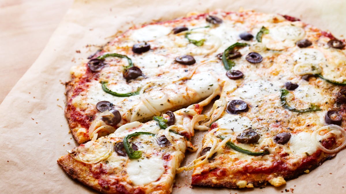 Pizza de coliflor baja en carbohidratos con pimientos verdes y aceitunas