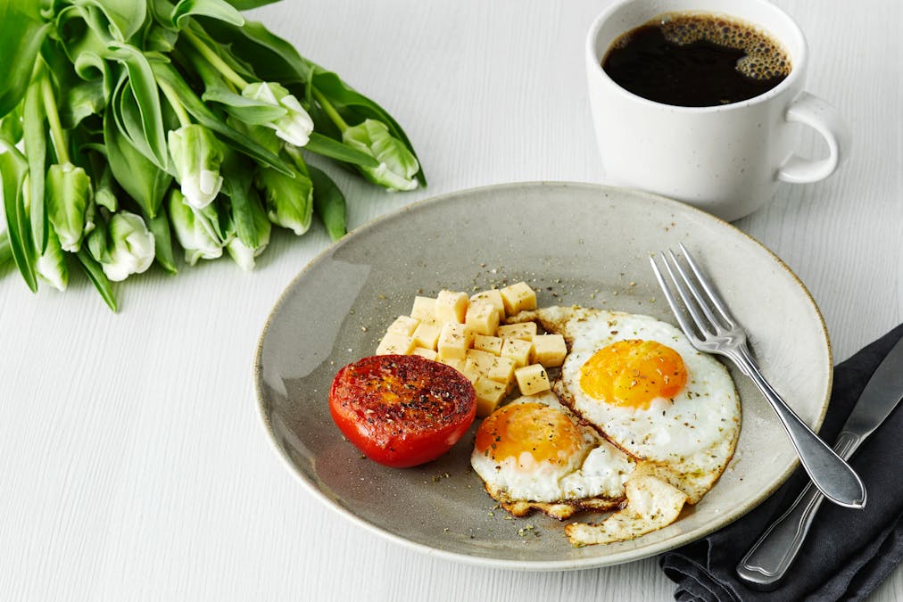 Desayuno con huevos fritos, tomate y queso