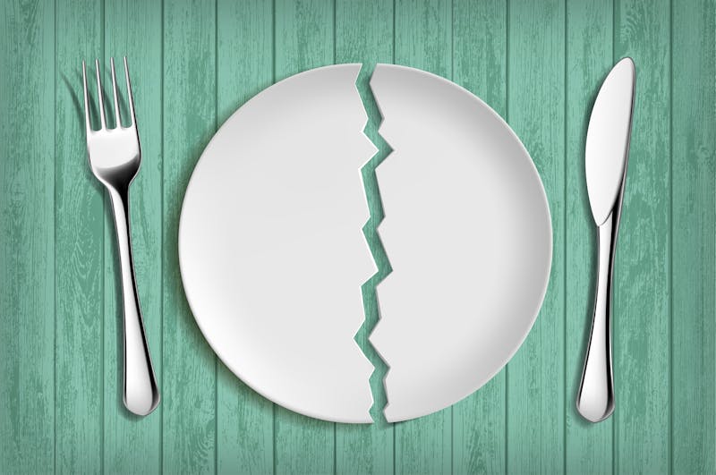 Broken white plate on a green wooden table. Healthy eating