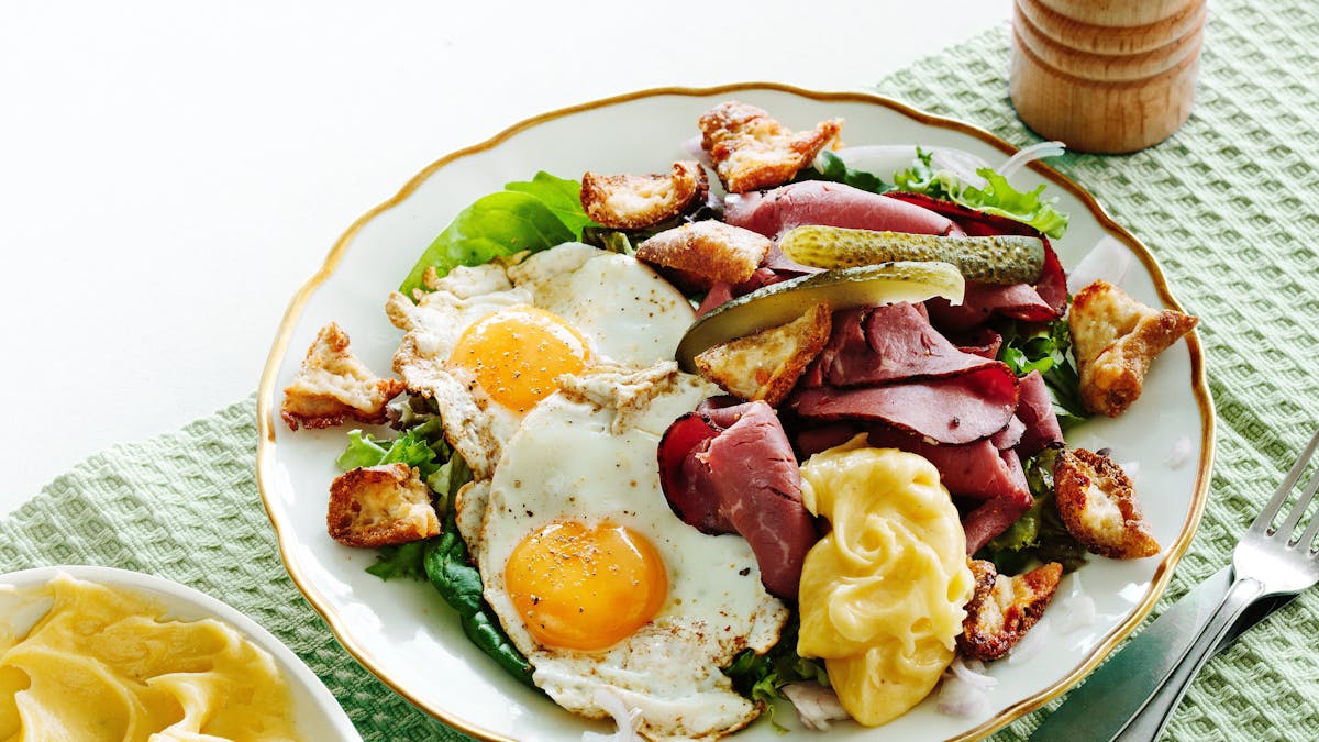 Ensalada keto de pastrami con huevos fritos y picatostes