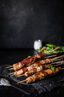 Brochetas de salmón envueltas en prosciutto