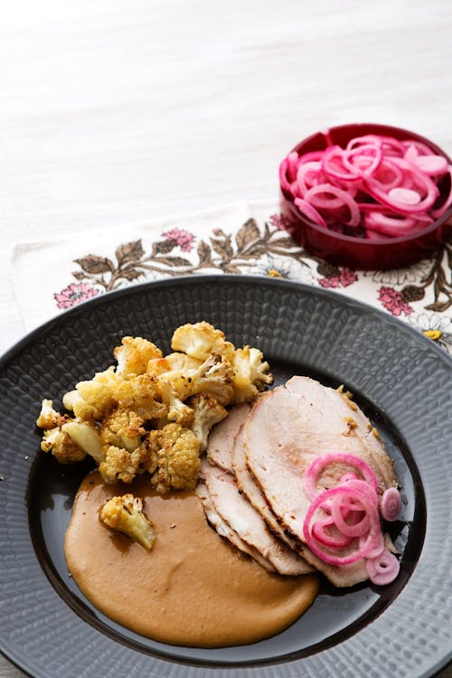 Cerdo asado con salsa cremosa y coliflor frita en mantequilla