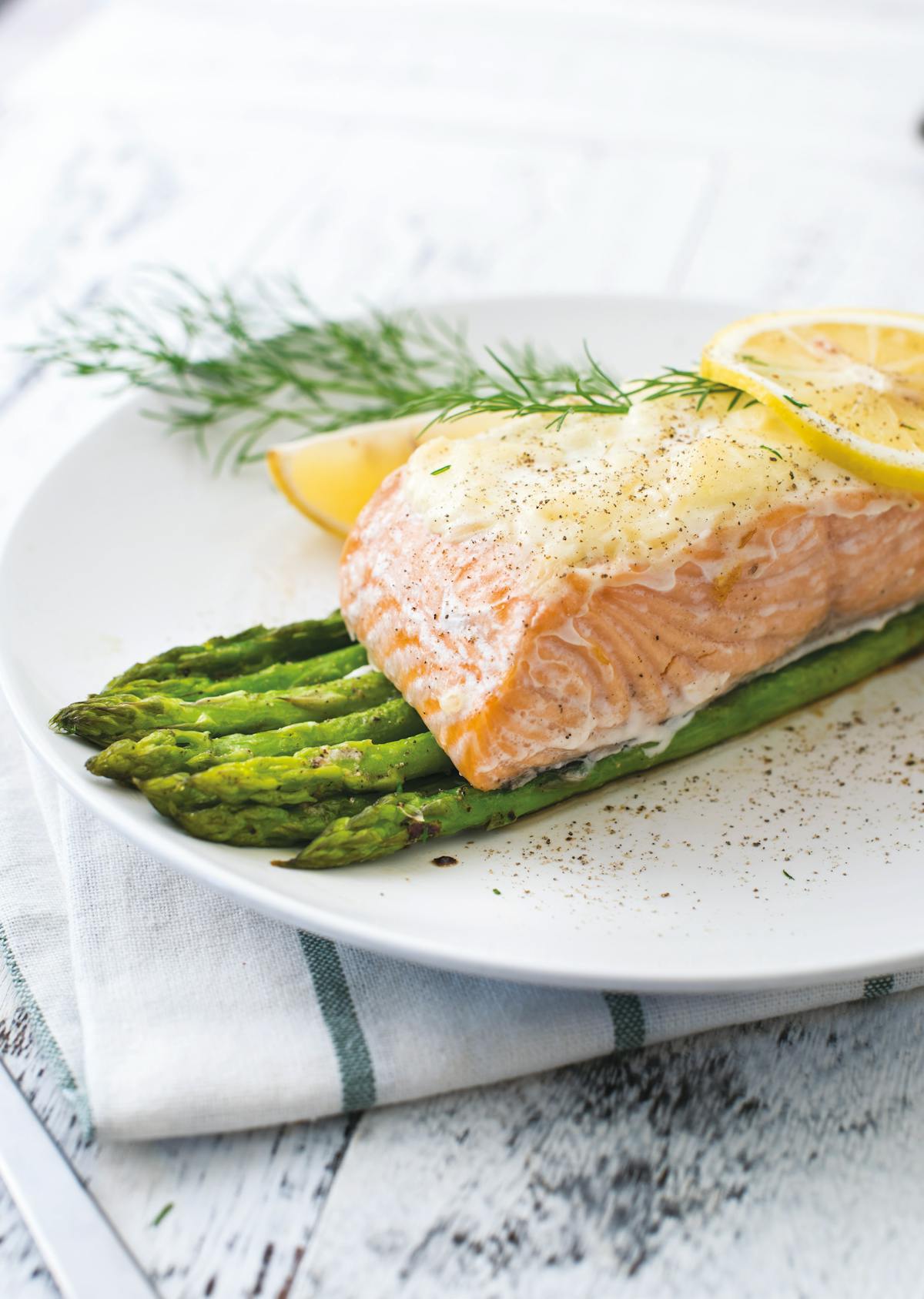 Salmón cubierto de queso parmesano con espárragos