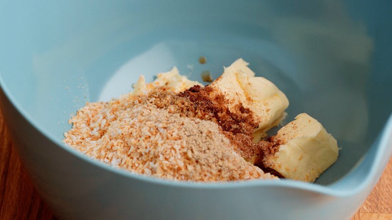 Mezclar la mantequilla, la mitad del coco rallado y las especias en un tazón