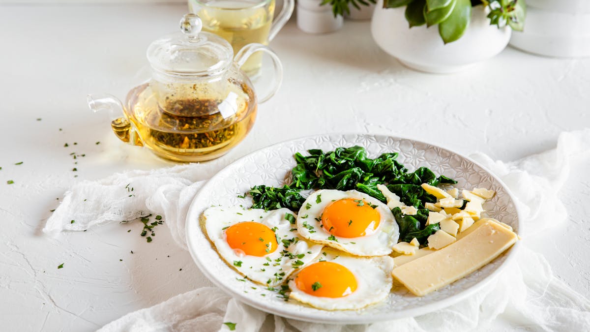 Desayuno alto en proteínas con queso, huevos y espinacas
