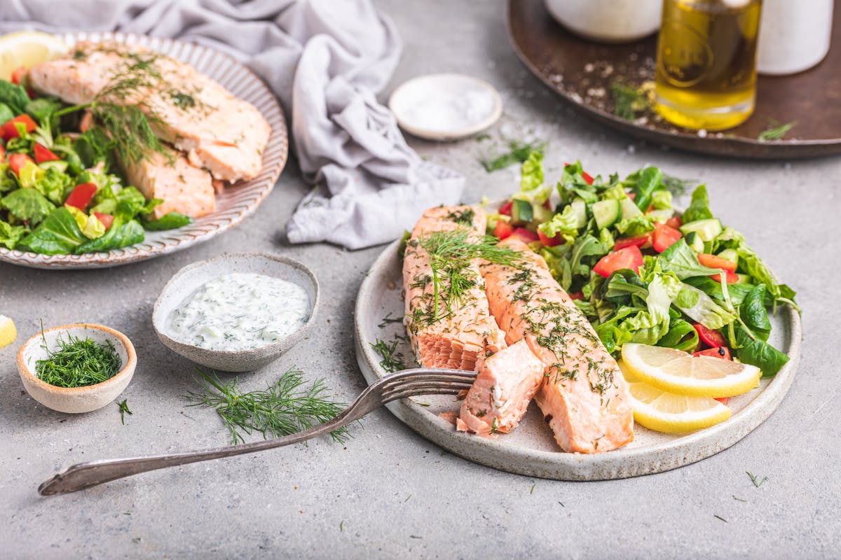 Salmón al horno con mantequilla, ensalada y tzatziki