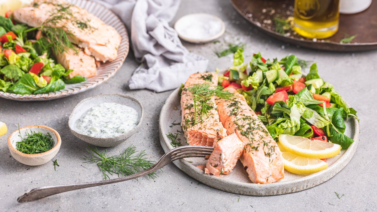 Salmón al horno con mantequilla, ensalada y tzatziki