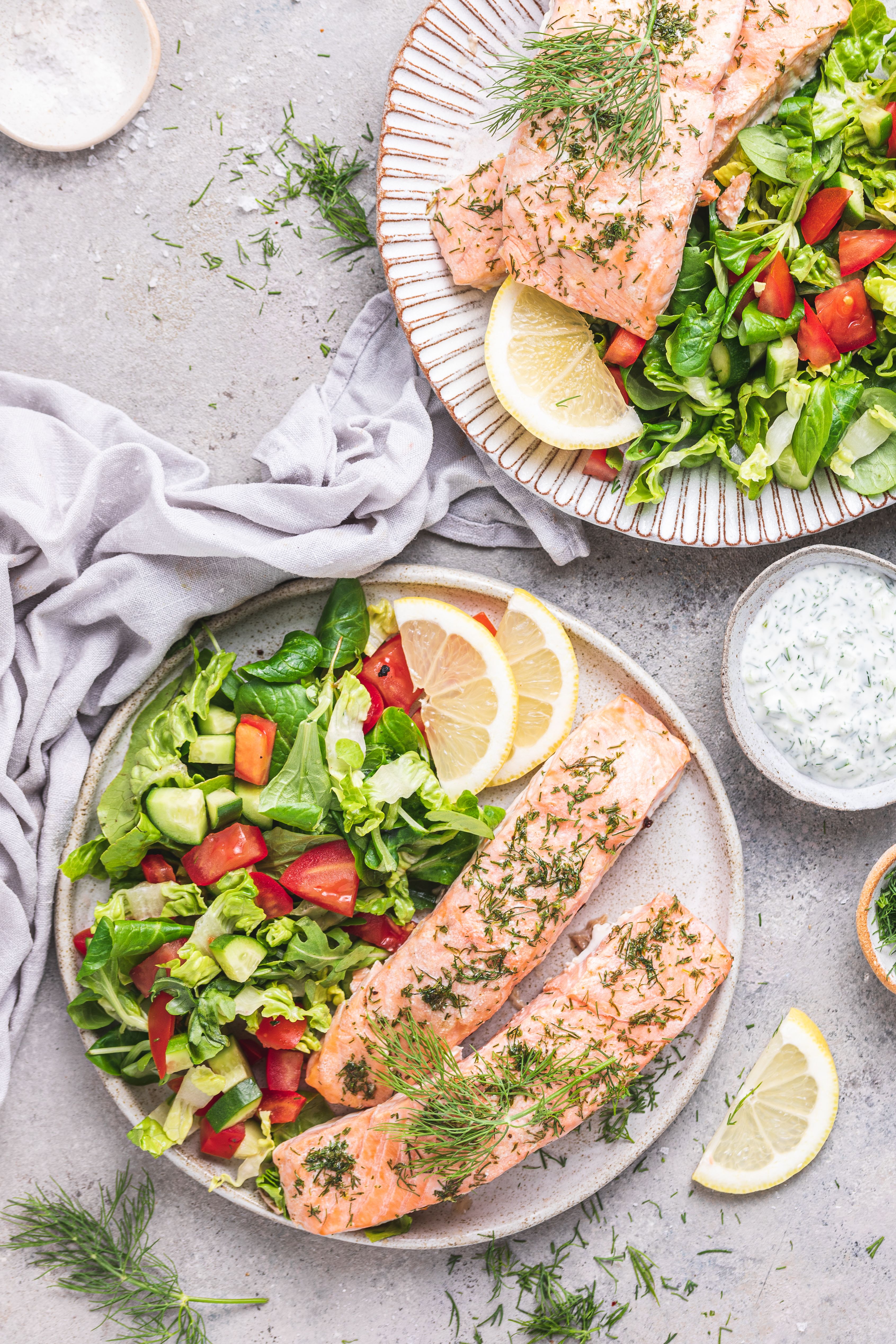 Salmón con mantequilla de limón con ensalada y tzatziki