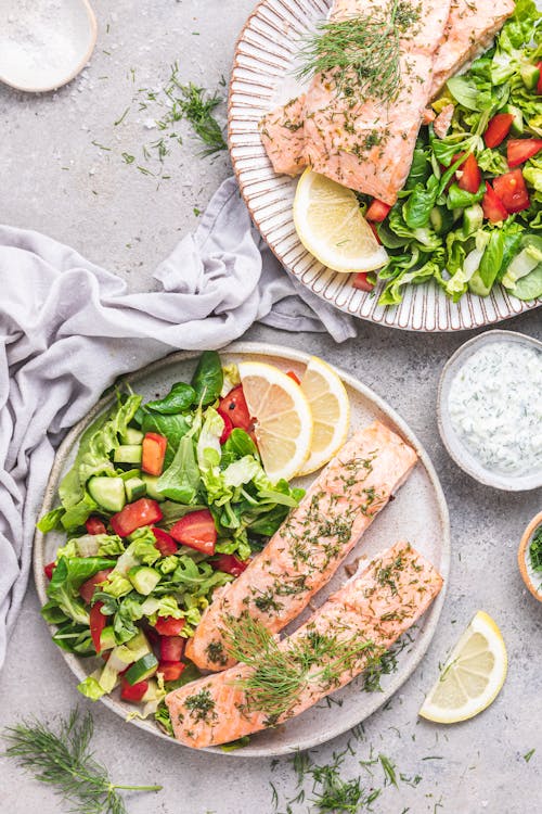 Salmón con mantequilla de limón con ensalada y tzatziki
