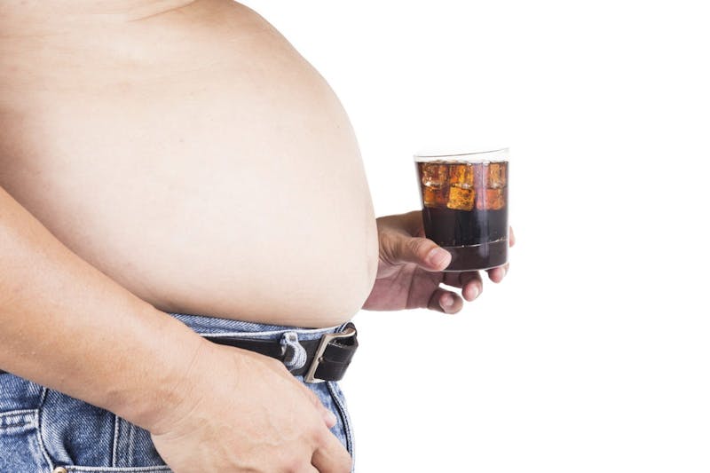 Man-with-big-belly-holding-a-glass-of-fizzy-soda-000066466471_Large-1600x1066