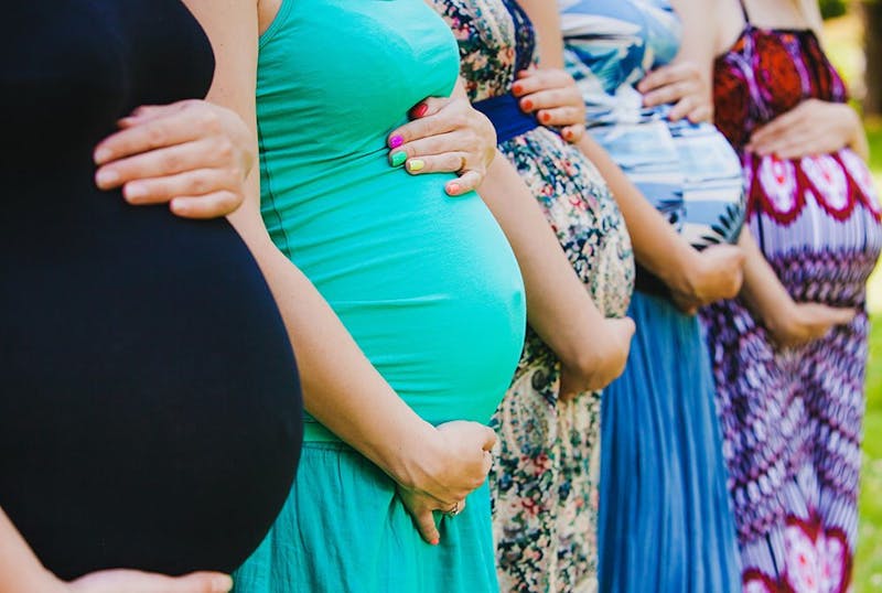 group_of_pregnant_women_holding_bellies-b397cd58