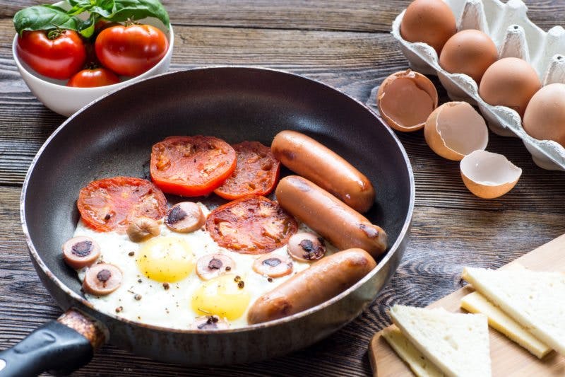 Fried breakfast with egg, sausages and baked tomato