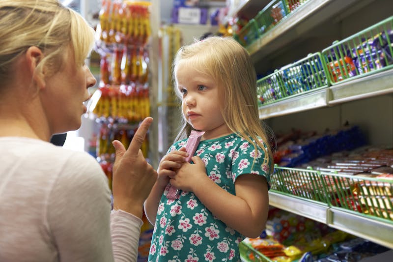 Girl Having Arguement With Mother At Candy Counter In Supermarket