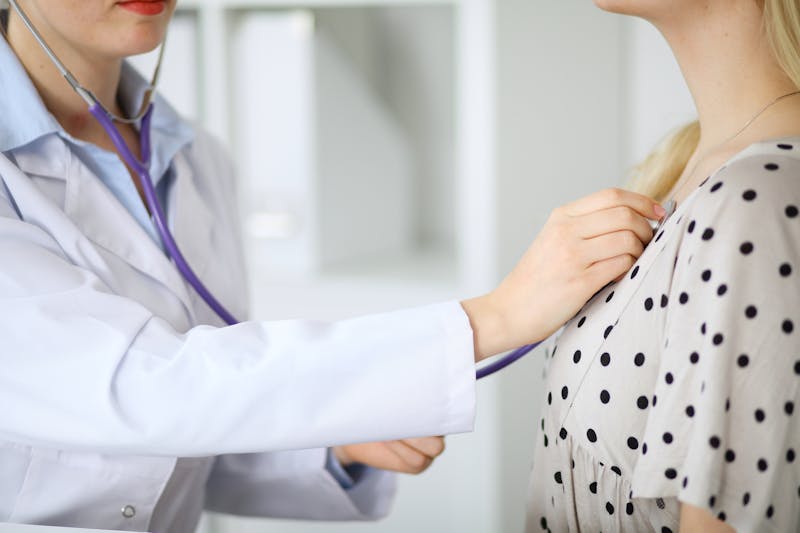 doctor examines a patient with a stethoscope