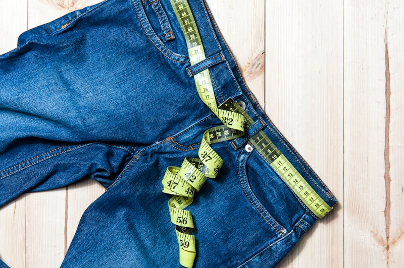 jeans and centimeter on a wooden background