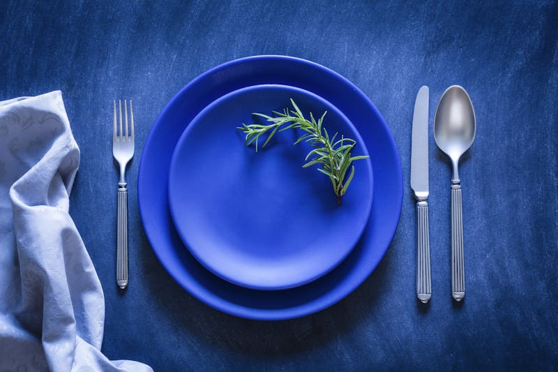 Blue toned place setting shot from above on dark background