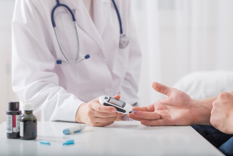 doctor measuring blood sugar young men