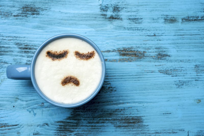 cup of cappuccino with a sad face