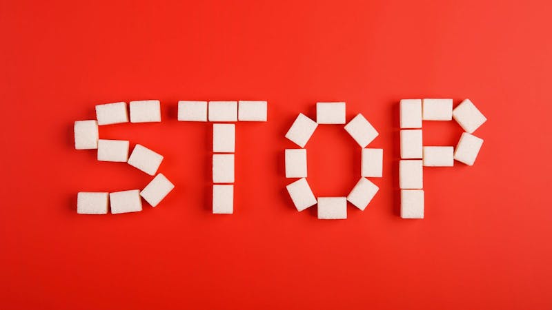 stop text from sugar cubes on red background