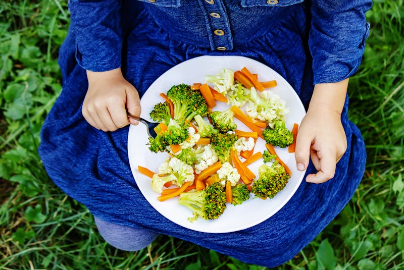 child eats vegetables. Summer photo. Selective focus