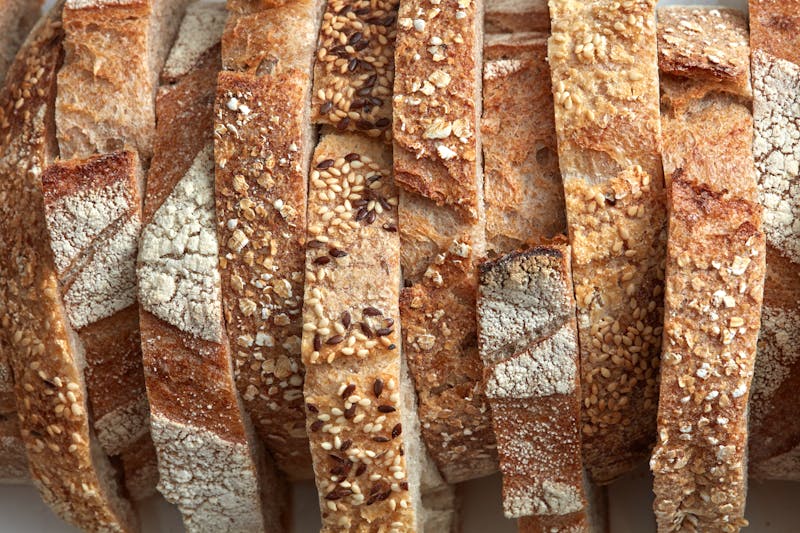 Macro photo of different pieces of fresh bread with flax seeds and sesame seeds. Healthy food. Flat lay