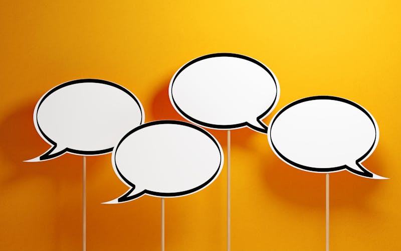 White Chat Bubbles With Wooden Sticks On Yellow Background