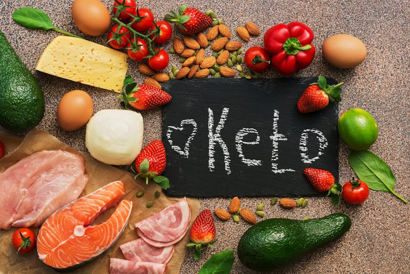 Keto diet food. Healthy low carbs products.Keto diet concept. Vegetables, fish, meat, nuts, seeds, strawberries, cheese. Top view. Signboard.