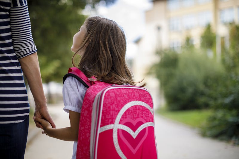 Mother taking her daughter to school