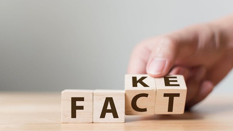 Fact or Fake concept, Hand flip wood cube change the word, April fools day