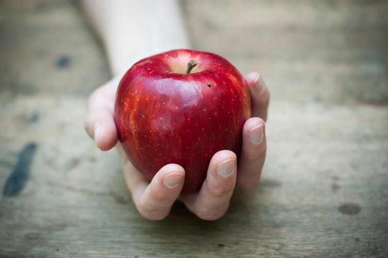 red apple temptation concept on wooden table background