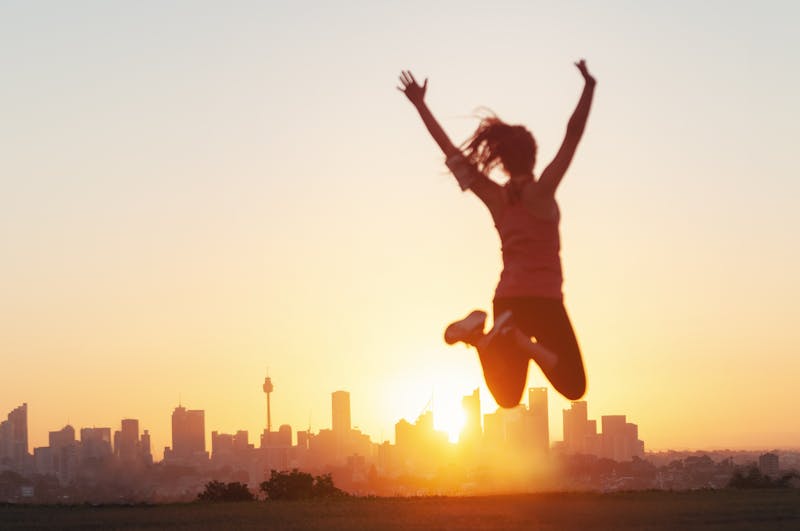 Sport women jumping and celebrating with arms raised.