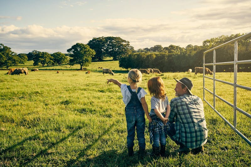 male farmer and his two kids on their farm