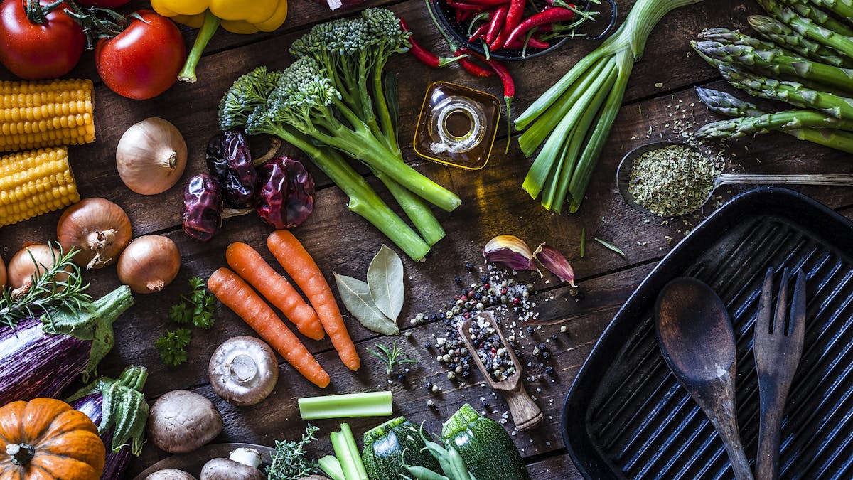 Fresh vegetables ready for cooking shot on rustic wooden table
