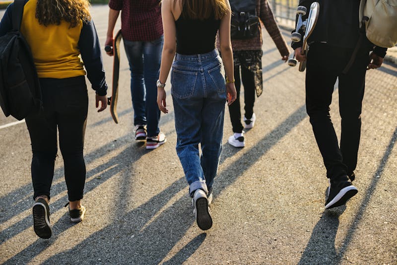 Rear view of group of school friends walking outdoors lifestyle