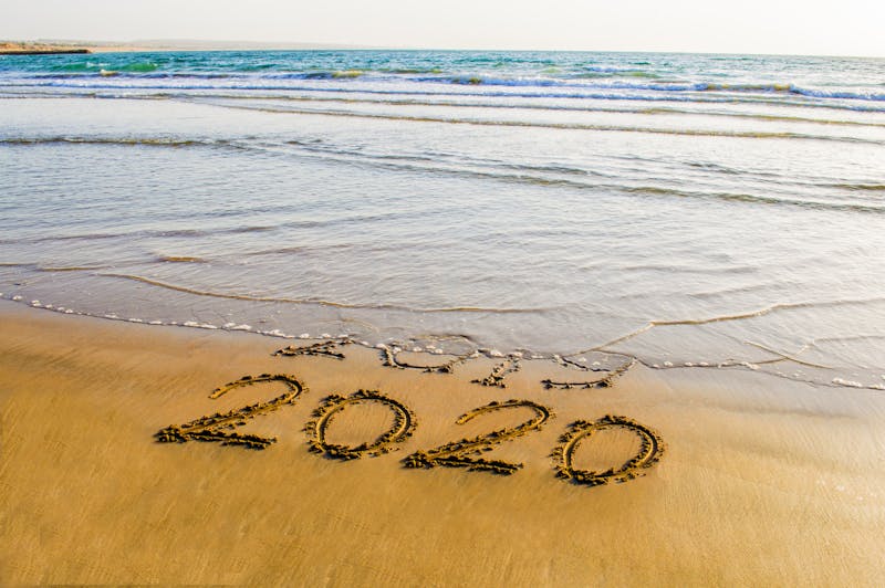 Happy New Year 2020 text on the sea beach. Abstract background photo of coming New Year 2020 and leaving year of 2019