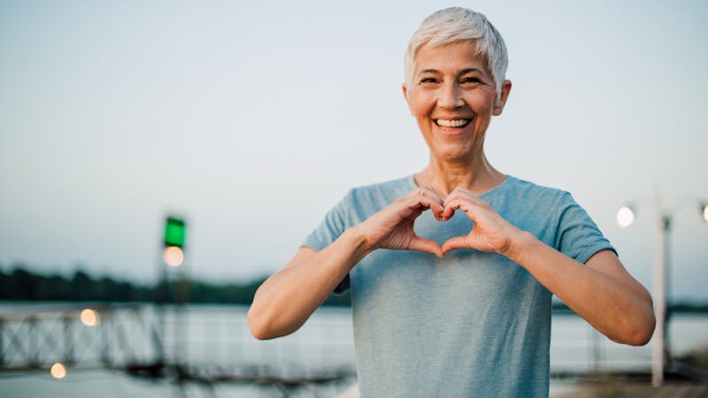 Active senior woman making a heart with her hands