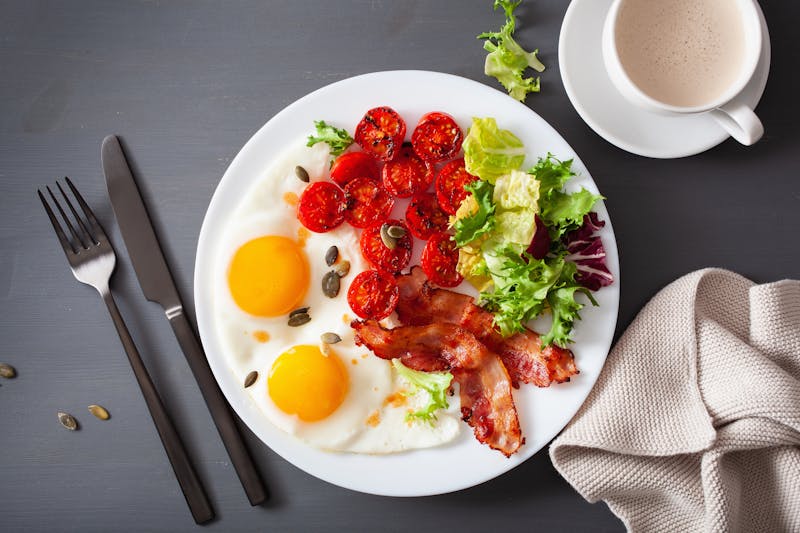 healthy keto diet breakfast: egg, tomatoes, salad leaves and bacon