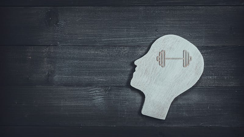 Human head and face with barbell sign on wood table background. Brain of thinking about health , Symbol of Process and Positive Mind concept