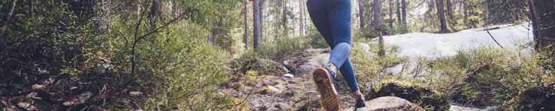 Woman trail runner running in forest.
