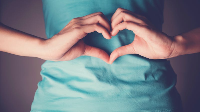 Woman hands making a heart shape on her stomach, healthy bowel degestion, probiotics  for gut health