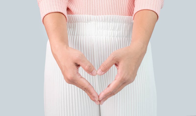 Close up view of young woman and Hand is a symbol of heart over her crotch. Feminine hygiene concept.
