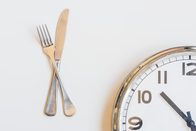 Knife and fork with clock on white background