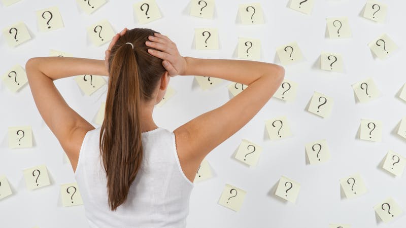 Young woman against stickers with questions