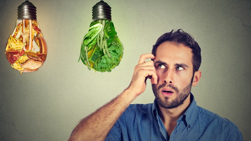 man thinking looking up at junk food green vegetables