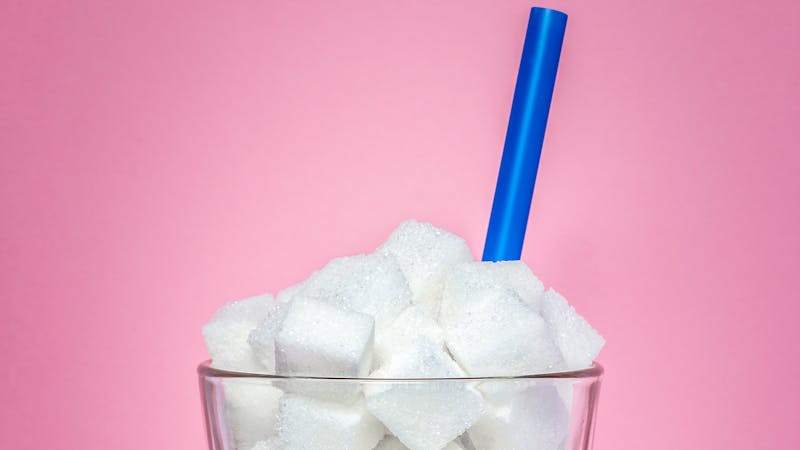 Glass full of sugar cubes – unhealthy diet concept.