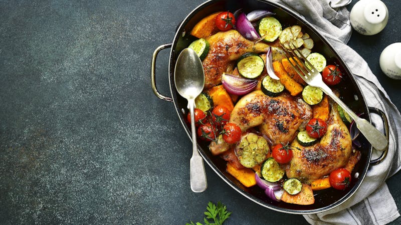 Chicken legs roasted with vegetables in a skillet pan