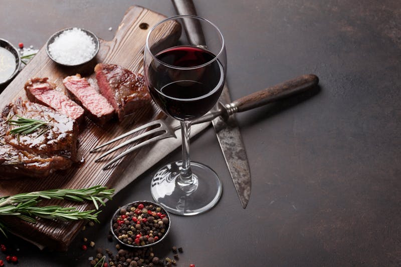 Grilled ribeye beef steak with red wine, herbs and spices