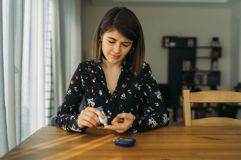 Young woman measuring blood sugar level
